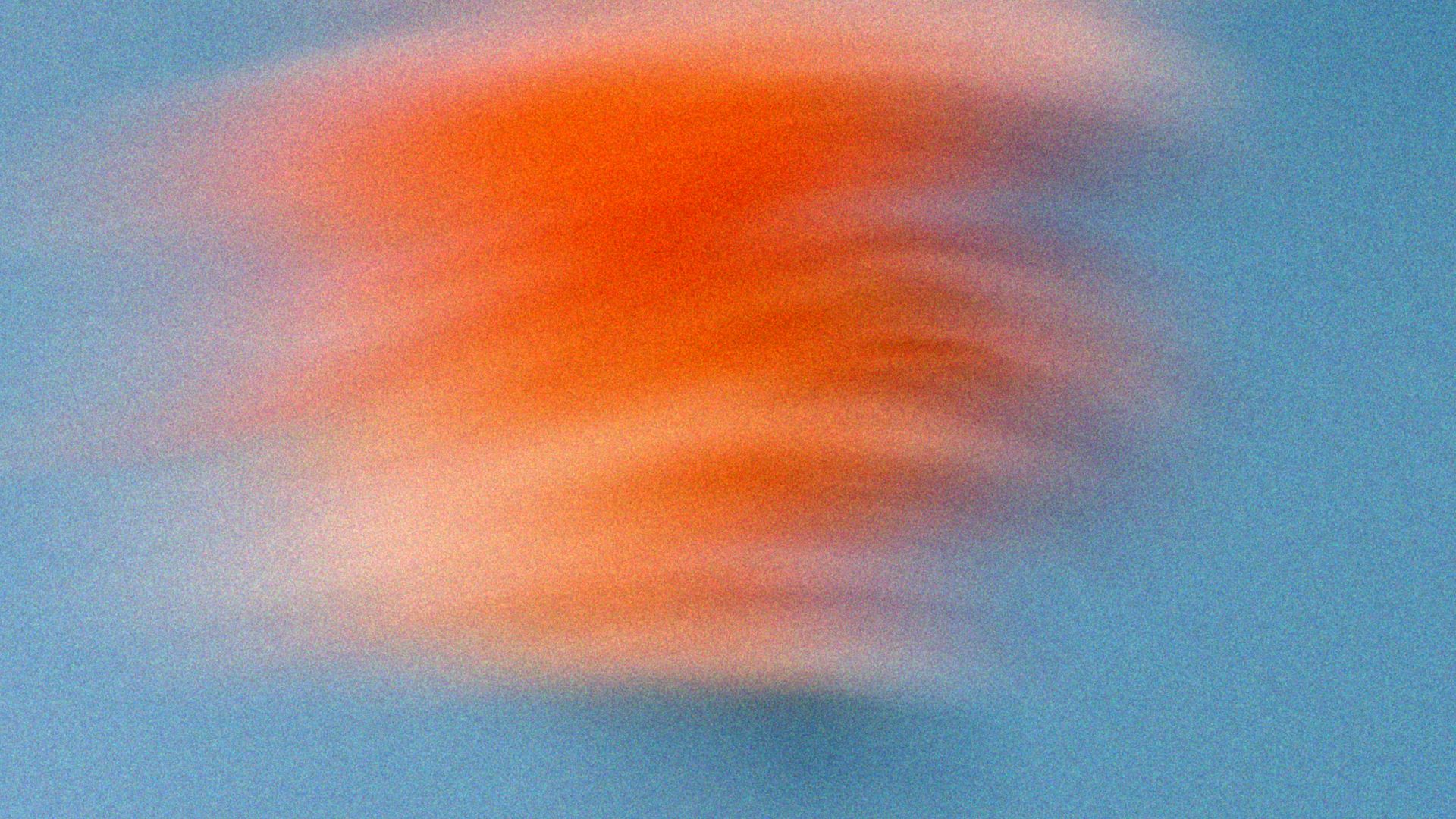 Blurred orange light on a blue background with film grain
